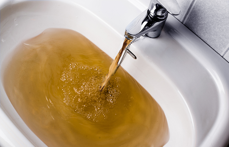 picture of a hand basin filling up with rusty brown water